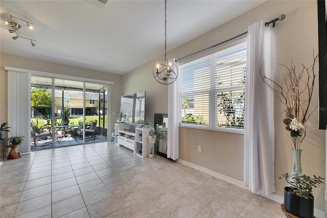 interior space with light tile patterned floors, baseboards, and a chandelier