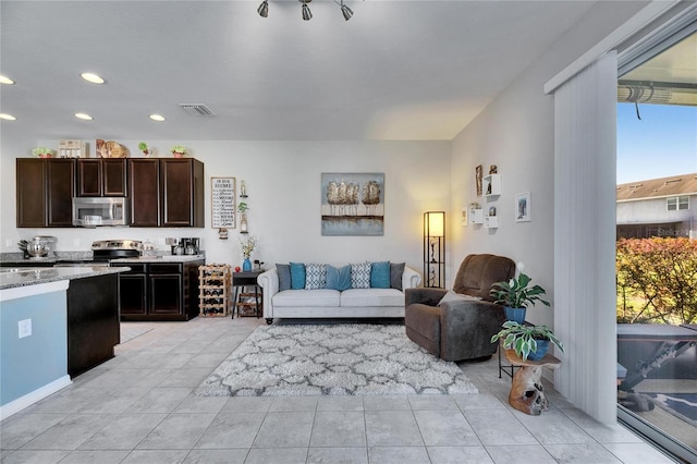 living area with recessed lighting, visible vents, and light tile patterned floors