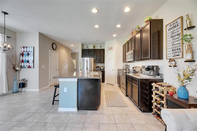 kitchen with a breakfast bar area, light stone countertops, recessed lighting, stainless steel appliances, and dark brown cabinetry