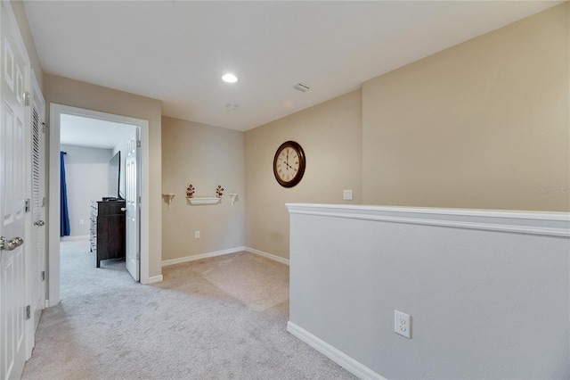 hallway with recessed lighting, light colored carpet, and baseboards