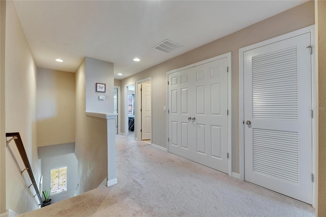 corridor featuring recessed lighting, visible vents, an upstairs landing, and carpet