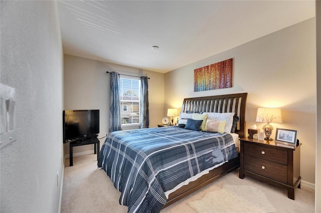 bedroom with light carpet and baseboards