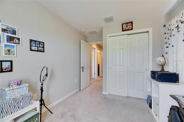 interior space with visible vents, light carpet, and baseboards