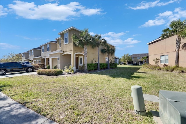 view of side of property with a residential view, a lawn, a garage, and stucco siding