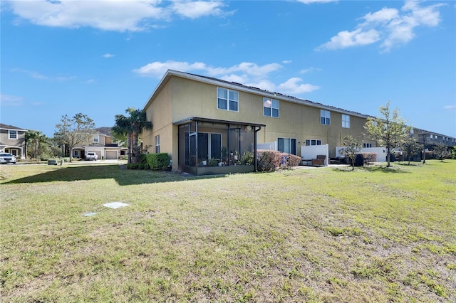 back of property featuring a lawn and a sunroom