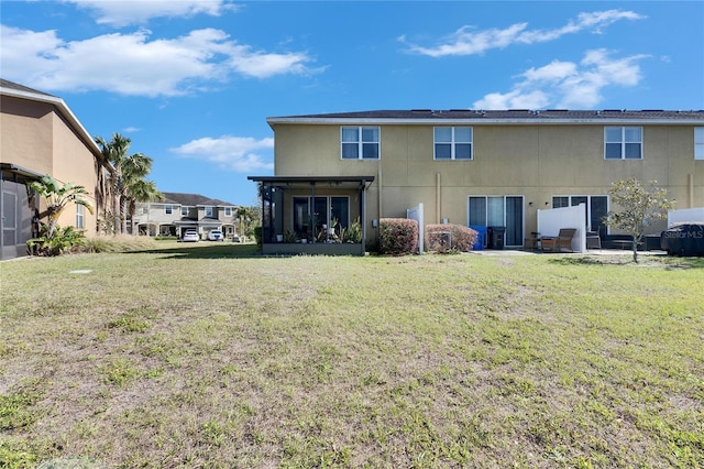 back of house with a patio area, a lawn, and a sunroom