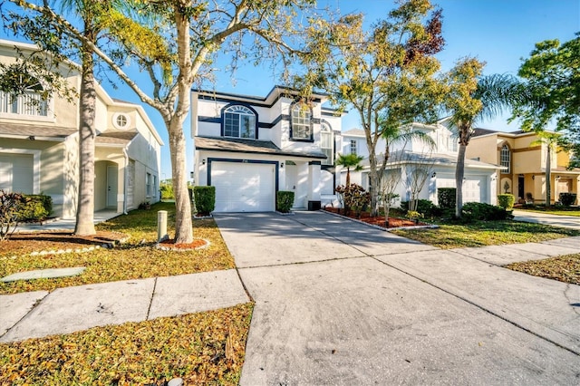 view of front of home featuring a garage, a residential view, concrete driveway, and stucco siding