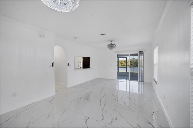 spare room featuring baseboards, visible vents, arched walkways, crown molding, and marble finish floor