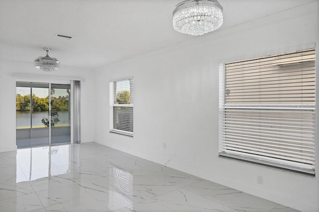 empty room featuring visible vents, marble finish floor, baseboards, and an inviting chandelier