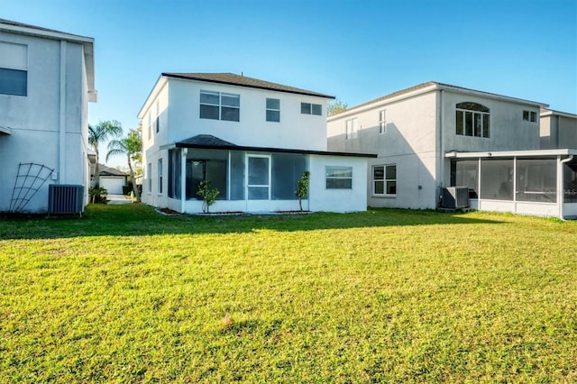 back of house featuring a yard, central AC unit, stucco siding, and a sunroom