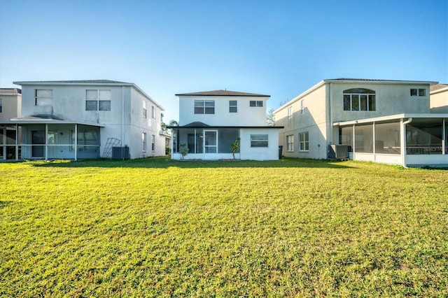 back of house with central AC, a yard, and a sunroom