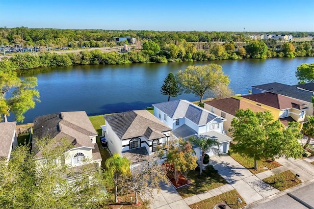 aerial view with a residential view, a water view, and a view of trees