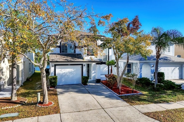 traditional home with concrete driveway, fence, roof with shingles, and stucco siding