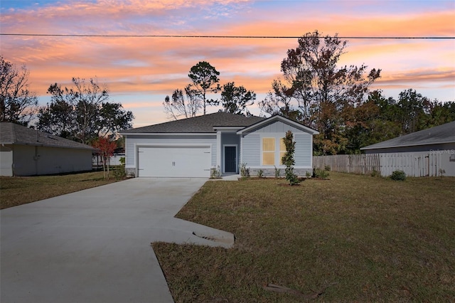 ranch-style house with driveway, fence, board and batten siding, a front yard, and an attached garage