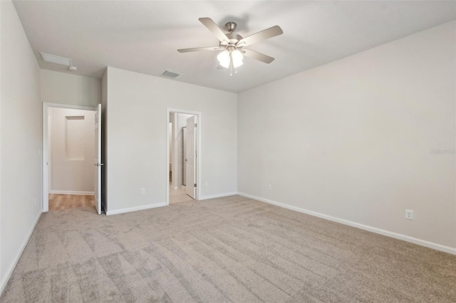 unfurnished bedroom featuring visible vents, light carpet, ensuite bathroom, baseboards, and ceiling fan