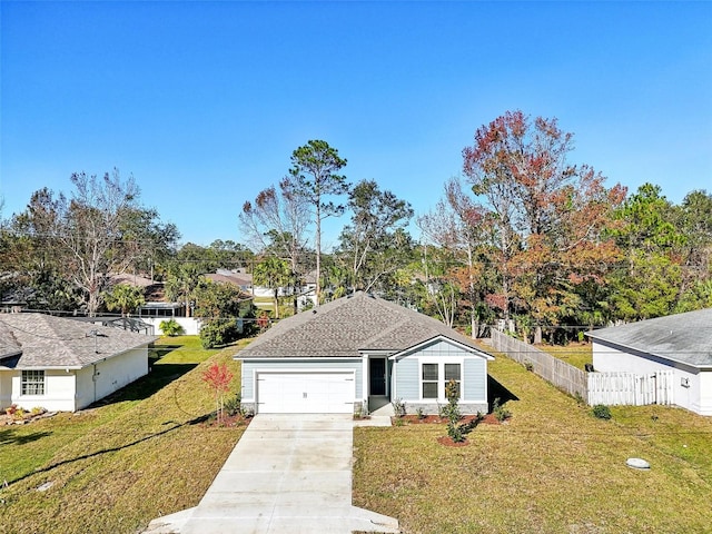 view of front facade featuring a front lawn, driveway, fence, roof with shingles, and a garage