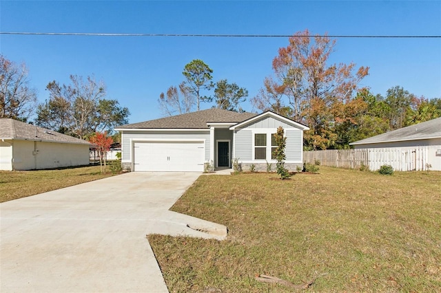 view of front of home with a garage, a front lawn, driveway, and fence