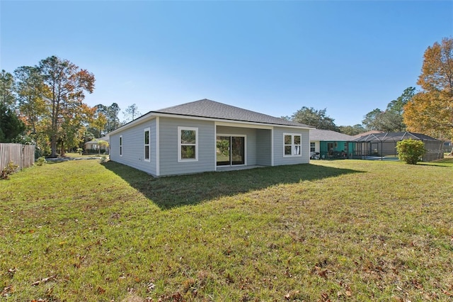 back of property with a yard and fence