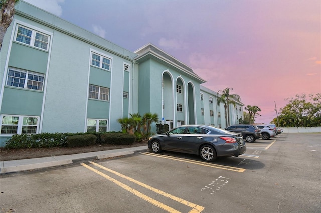 property at dusk featuring uncovered parking