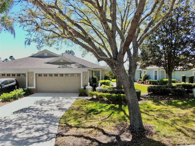 ranch-style house with stucco siding, a front yard, concrete driveway, and an attached garage