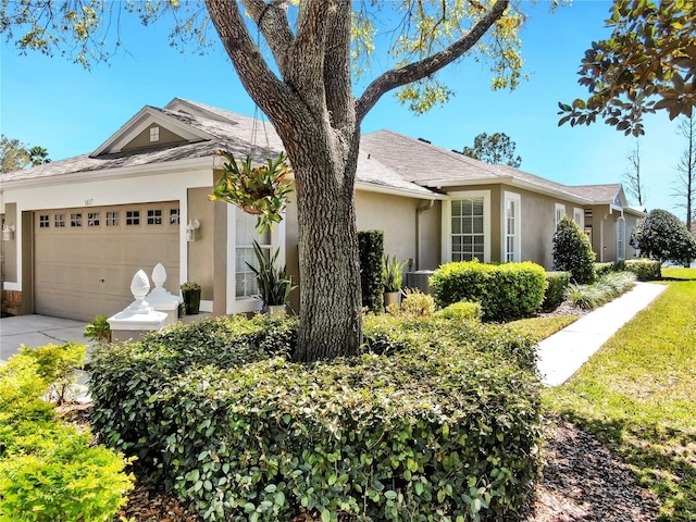 ranch-style house with an attached garage, cooling unit, and stucco siding