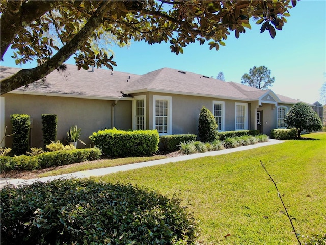 ranch-style home featuring stucco siding and a front yard