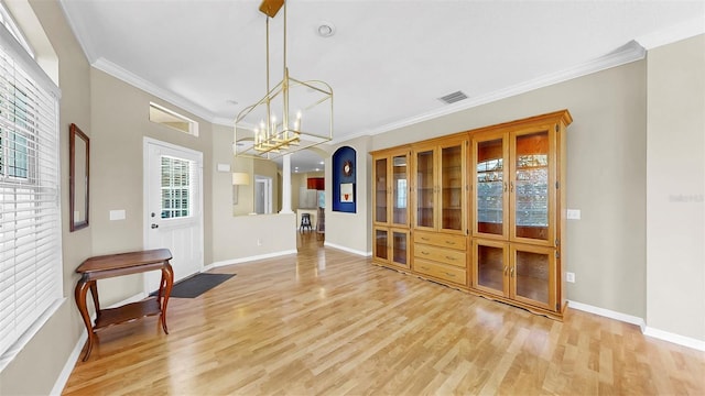 dining room with visible vents, baseboards, light wood-style floors, and ornamental molding