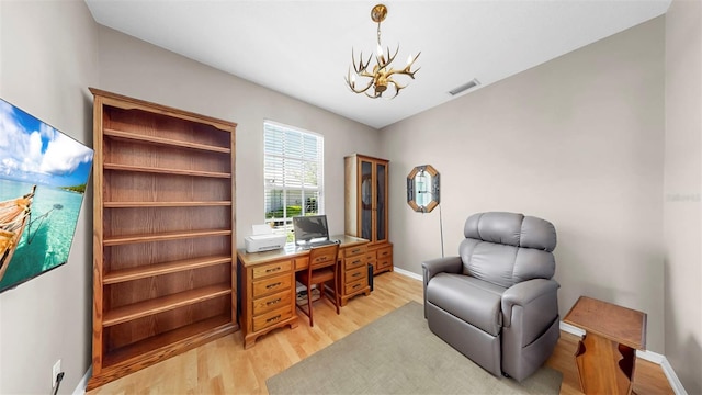 office featuring a notable chandelier, visible vents, baseboards, and light wood-style floors