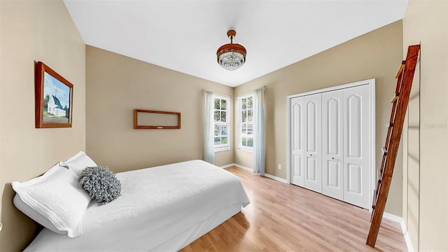 bedroom with a closet, baseboards, and light wood-style floors