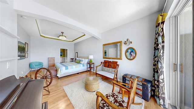 bedroom featuring a tray ceiling, wood finished floors, and arched walkways