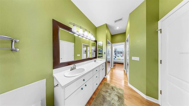 full bathroom featuring a sink, visible vents, baseboards, and double vanity