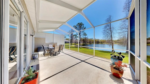 unfurnished sunroom featuring lofted ceiling and a water view