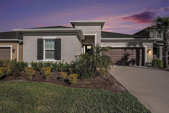 view of front of property featuring a garage, driveway, and stucco siding