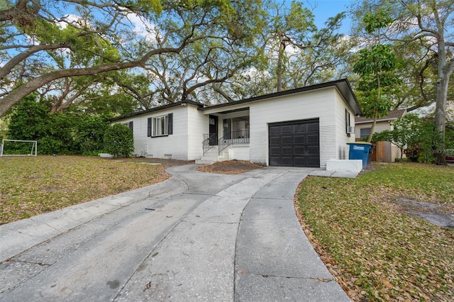 ranch-style house with a front yard, an attached garage, driveway, and crawl space