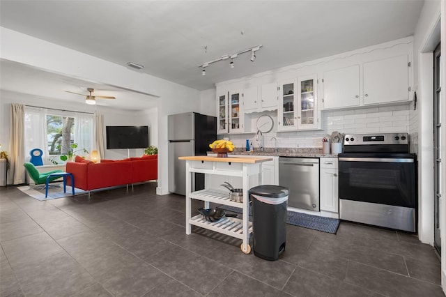 kitchen featuring decorative backsplash, white cabinetry, stainless steel appliances, and visible vents