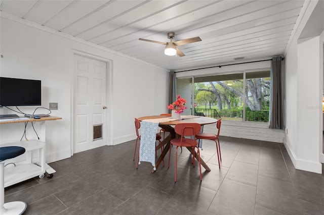 tiled dining space featuring baseboards and a ceiling fan