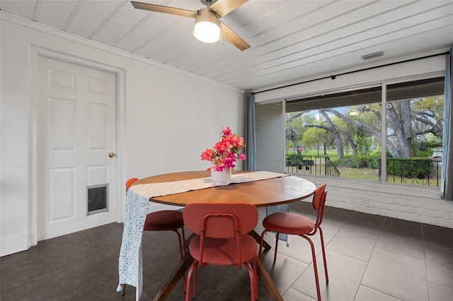 dining space featuring tile patterned flooring, crown molding, and a ceiling fan