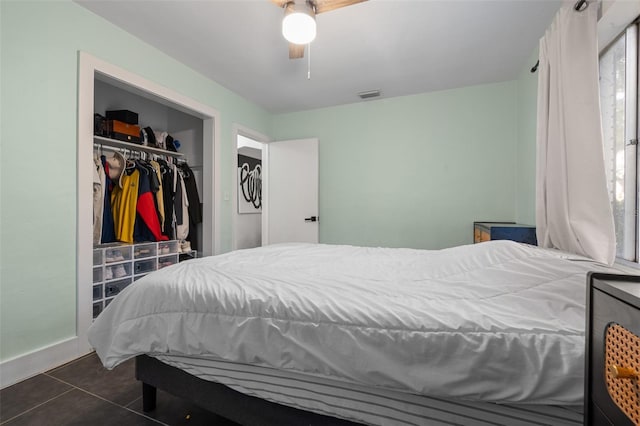 bedroom featuring a closet, visible vents, a ceiling fan, and dark tile patterned flooring