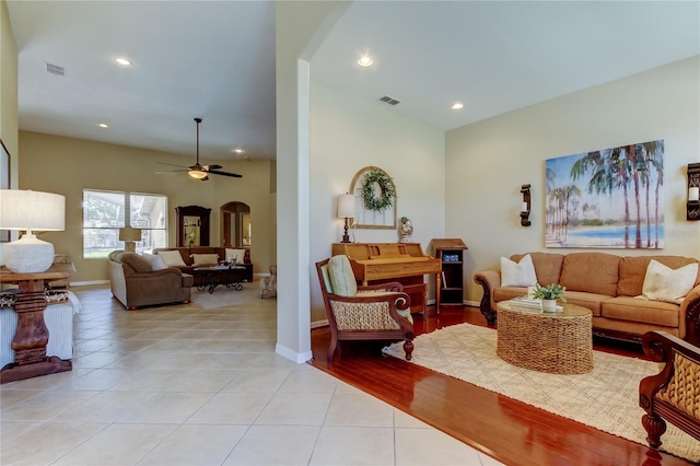 living area with visible vents, a ceiling fan, recessed lighting, arched walkways, and light tile patterned floors