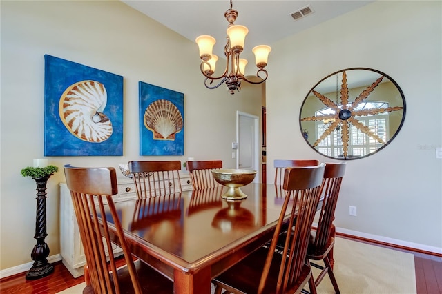 dining area with visible vents, baseboards, a notable chandelier, and wood finished floors