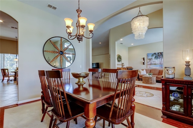 tiled dining room featuring recessed lighting, visible vents, arched walkways, and a chandelier