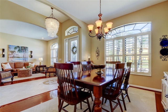 dining space featuring arched walkways, a wealth of natural light, and a chandelier