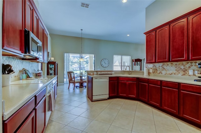 kitchen with dishwasher, stainless steel microwave, visible vents, and reddish brown cabinets