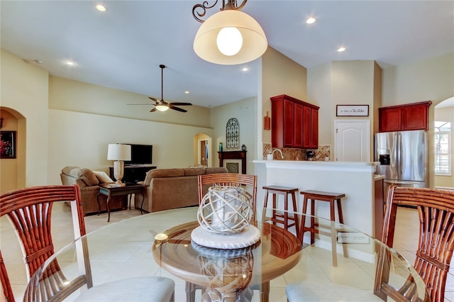 dining area with light tile patterned floors, recessed lighting, arched walkways, and ceiling fan