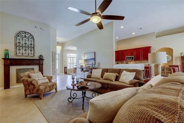 living room with ceiling fan, recessed lighting, light tile patterned flooring, arched walkways, and high vaulted ceiling