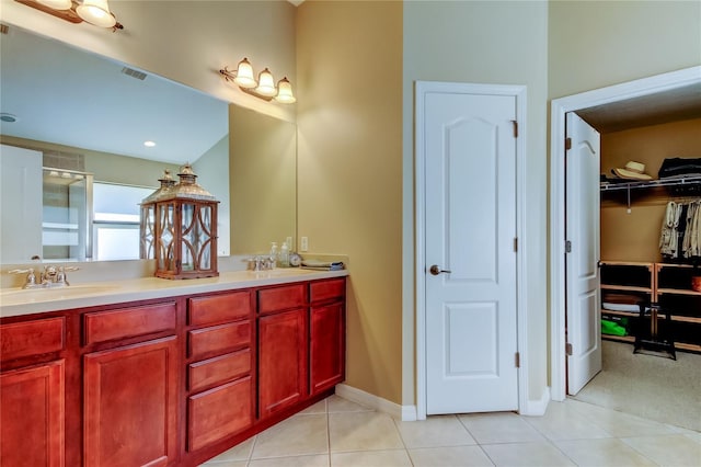 bathroom featuring double vanity, tile patterned flooring, an enclosed shower, and a sink