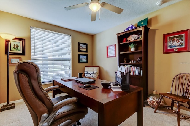 home office featuring light colored carpet, baseboards, and ceiling fan