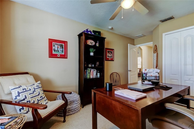 home office with visible vents, light colored carpet, and a ceiling fan