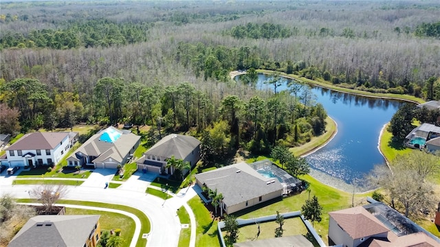 drone / aerial view featuring a forest view, a water view, and a residential view