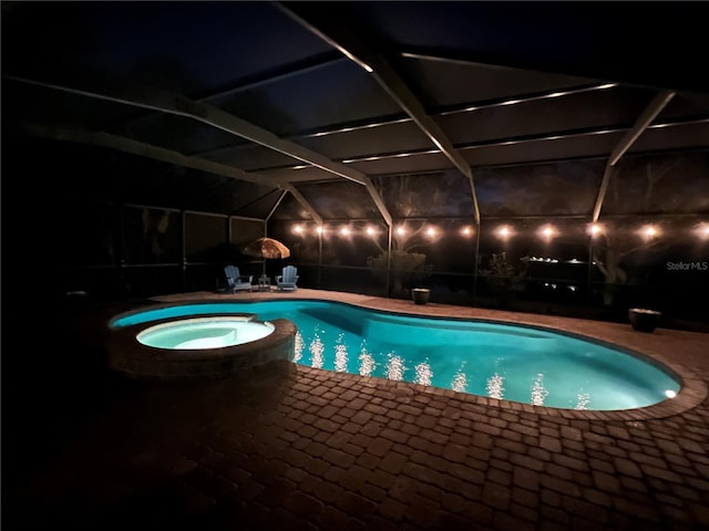 view of swimming pool with a patio area, glass enclosure, and a pool with connected hot tub